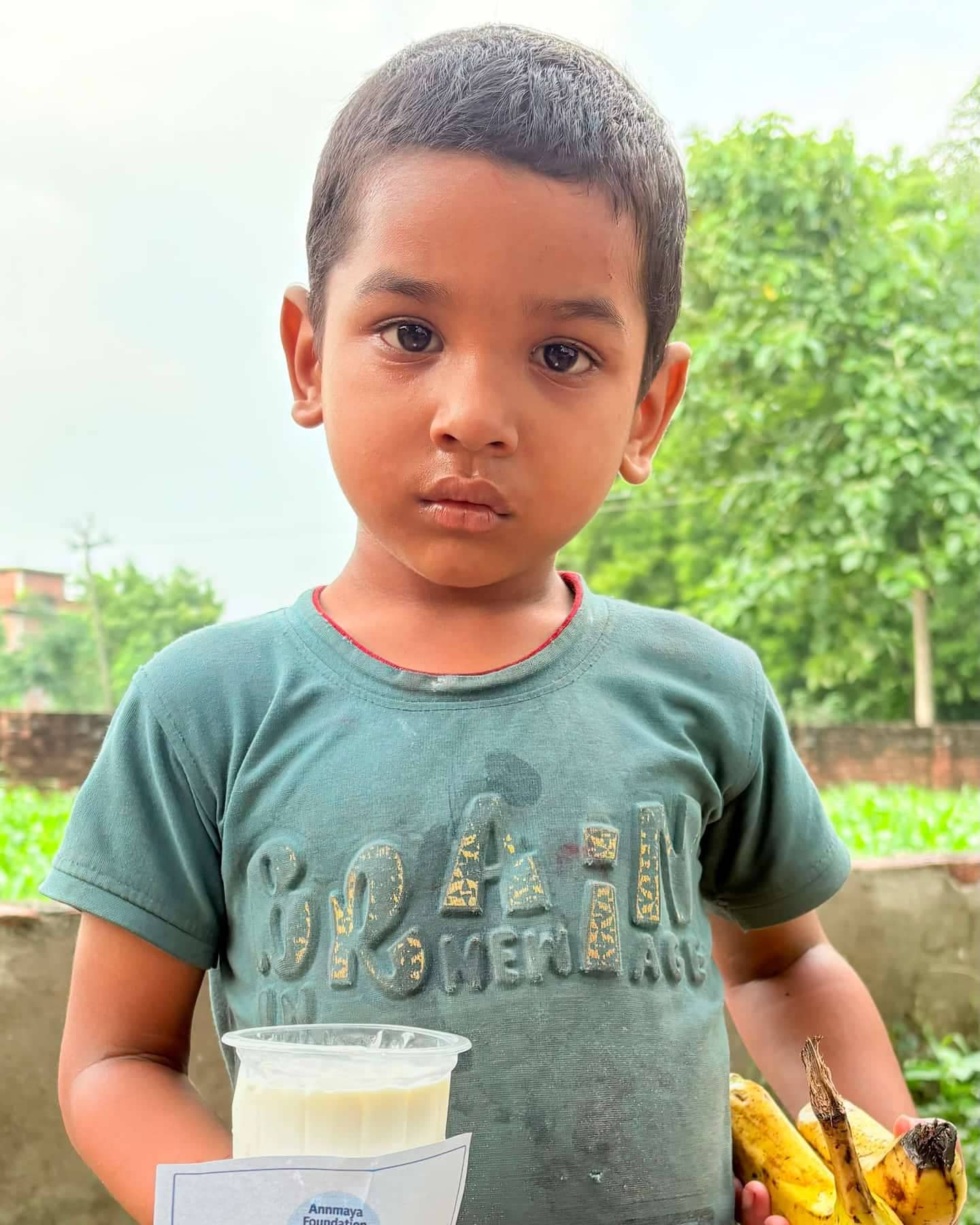Children receiving milk and bananas at an Annmaya Foundation distribution in Varanasi