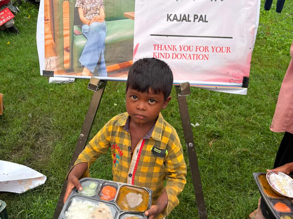 A child holding a glass of milk, outdoors